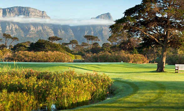 low mist hangs over the fairways with Table Mountain in the background.