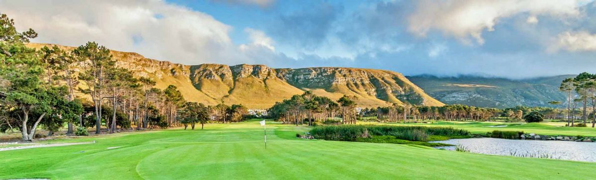 Verdant fairways and lakes are nestled beneath the mountain range in Hermanus.