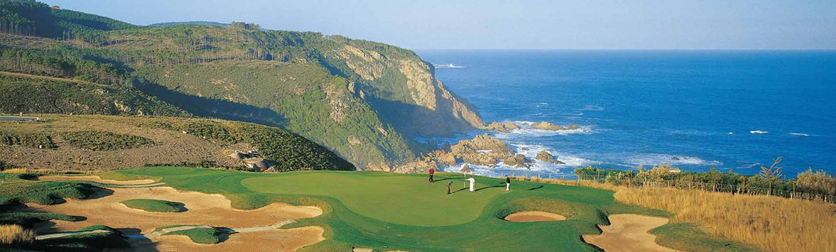 Golfers on the green of Pezulas signature golf hole perched on the cliffs over the Indian ocean.