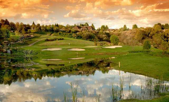 clouds reflected in the foreground lake in front of the fairways.