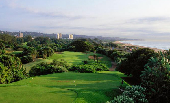 aerial views of the course at Durban Country club with the ocean and city buildings on the horizon.