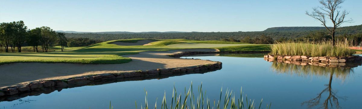 tranquil views across the lake at Legend Golf club with large sandy waste bunkers ready to catch errant golf balls that fall short of the green.