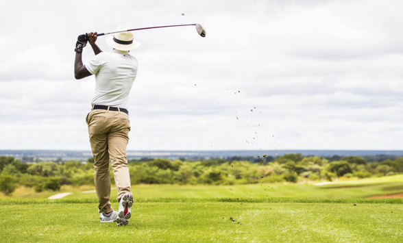 Golfer hitting ball off tee box at Euphoria Golf Club.