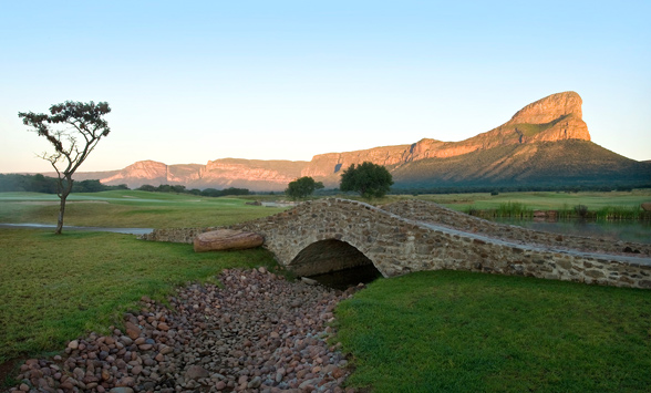 The rising sun illuminates the Hang-up Mountain range whilst in the foreground the bridge and stream stay in the shadows.