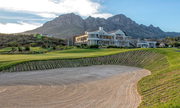 Deep pot bunker with radiating railway sleepers in front of the 18th green and clubhouse at Erinvale.