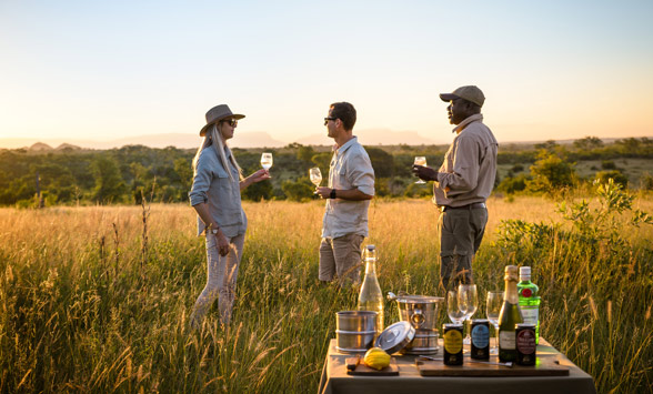 Couple enjoying sun downer drinks as part of their safari holiday.