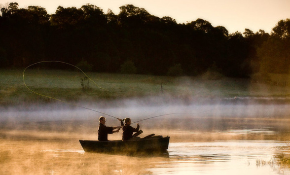 Fly fishing on the lake at Hartford House as the mist clears.