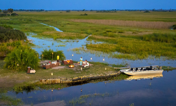 Romantic dinner with torches set up on the side of a channel in the Delta.