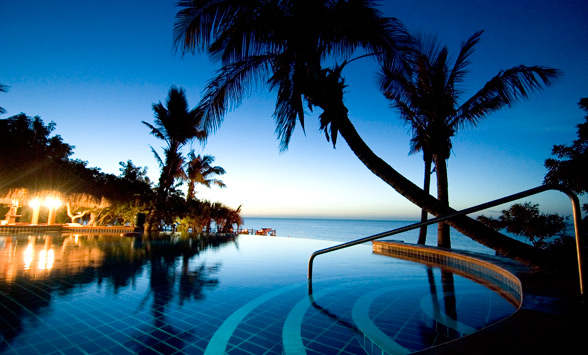 sun setting in Bazaruto over the swim up pool bar at the Anantara Island Resort.