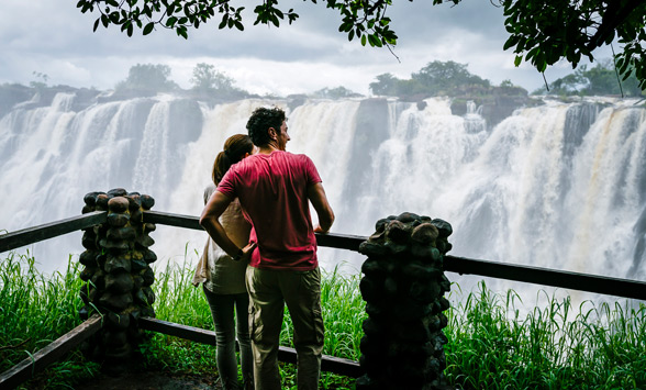 two people watching at the water flowing over the Victoria Falls in Zambia.