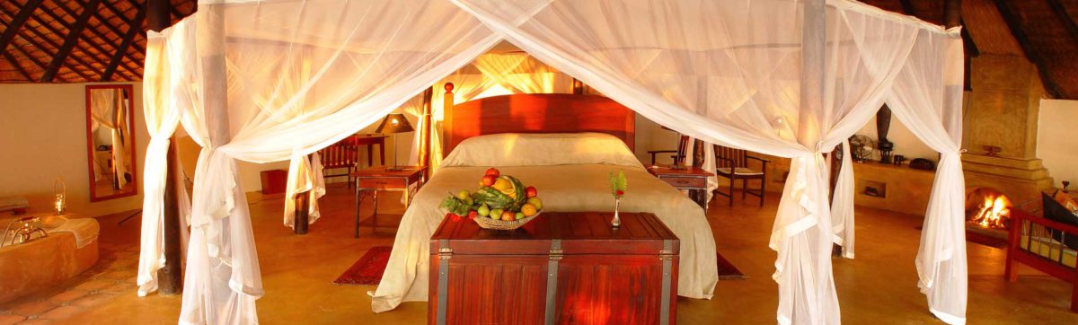 romantic honeymoon suite with king size bed draped in muslin mosquito nets and flowers.