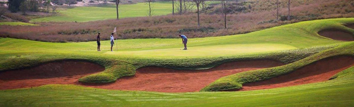 golfers sinking their putts on the green of the Fire Course, Dubai.