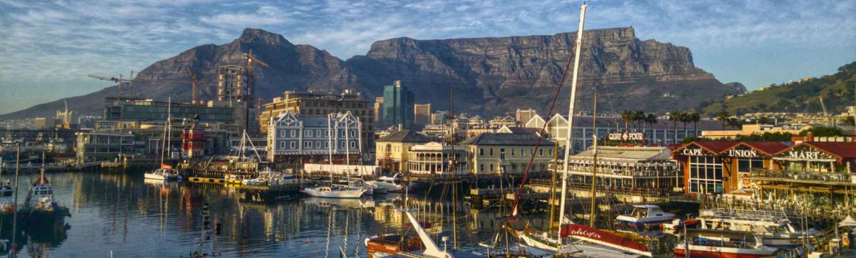 light clouds over Table Mountain and the V&A Waterfront with boats in the harbour.