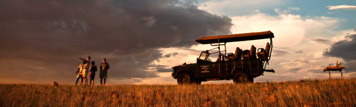 Guest enjoying sun downer drinks as part of a game drive in Namibia.