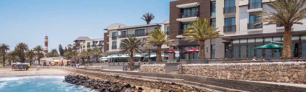 Exterior to the Strand Hotel with Atlantic Ocean waves crashing over the mole in front.