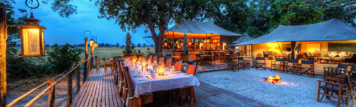 Sunset at Kadikora Safari Lodge where the dinner table is lit by hurricane lamps.