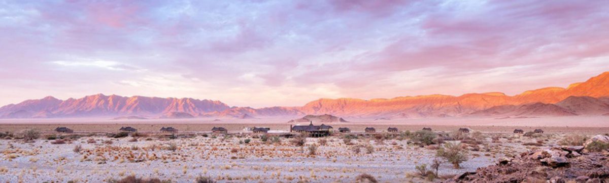 panoramic view of Hoodia Desert Lodge with mountains behind.